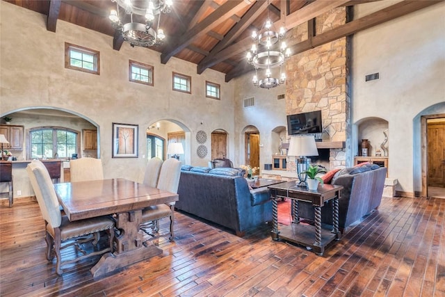 171 Oak Grove Cv, Georgetown, TX 78628 - living area with a chandelier, high vaulted ceiling, hardwood / wood-style floors, arched walkways, and a wooden ceiling with exposed beams