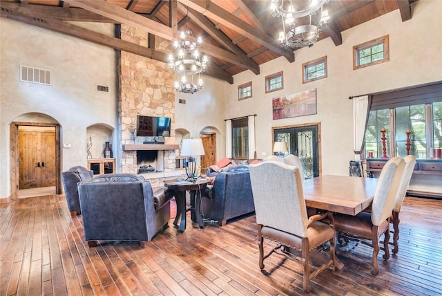 171 Oak Grove Cv, Georgetown, TX 78628 - dining space with high vaulted ceiling, a chandelier, arched walkways, wood-type flooring, and a wood ceiling with exposed beams