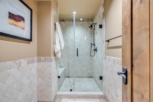 171 Oak Grove Cv, Georgetown, TX 78628 - bathroom with a shower stall, tile walls, and recessed lighting