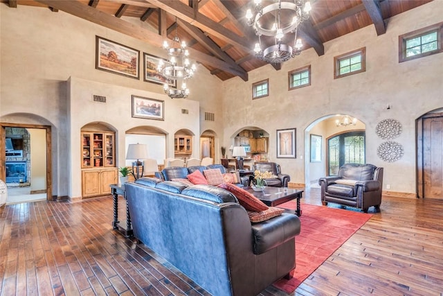 171 Oak Grove Cv, Georgetown, TX 78628 - living room with a chandelier, high vaulted ceiling, arched walkways, dark wood finished floors, and a wood ceiling with exposed beams