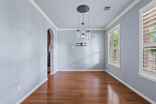 908 Golden Palomino Ct, Austin, TX 78732 - unfurnished dining area featuring arched walkways, crown molding, and wood finished floors