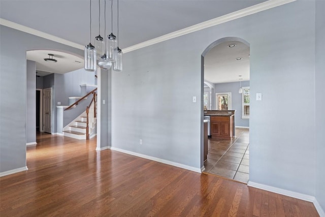 908 Golden Palomino Ct, Austin, TX 78732 - spare room with stairs, wood finished floors, a chandelier, crown molding, and arched walkways