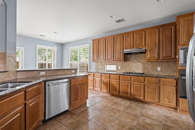908 Golden Palomino Ct, Austin, TX 78732 - kitchen featuring appliances with stainless steel finishes, under cabinet range hood, brown cabinetry, and recessed lighting
