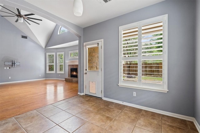 908 Golden Palomino Ct, Austin, TX 78732 - spare room with light tile patterned floors, a ceiling fan, lofted ceiling, and a tiled fireplace