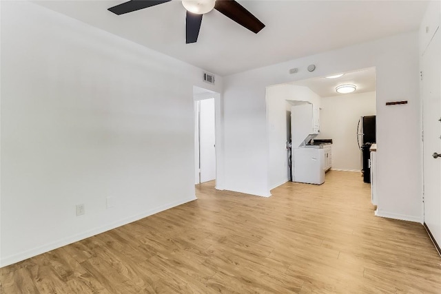 2401 Manor Rd Unit 210, Austin, TX 78722 - unfurnished living room with a ceiling fan, washer / clothes dryer, and light wood finished floors
