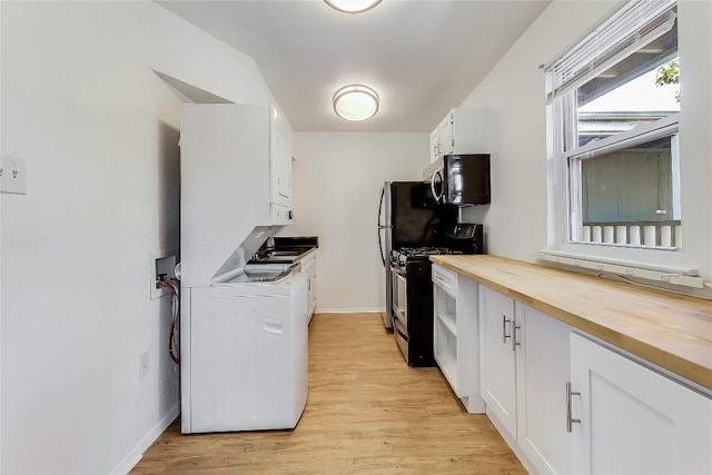 2401 Manor Rd Unit 210, Austin, TX 78722 - kitchen with stainless steel microwave, stacked washer / drying machine, range with gas cooktop, butcher block counters, and white cabinetry