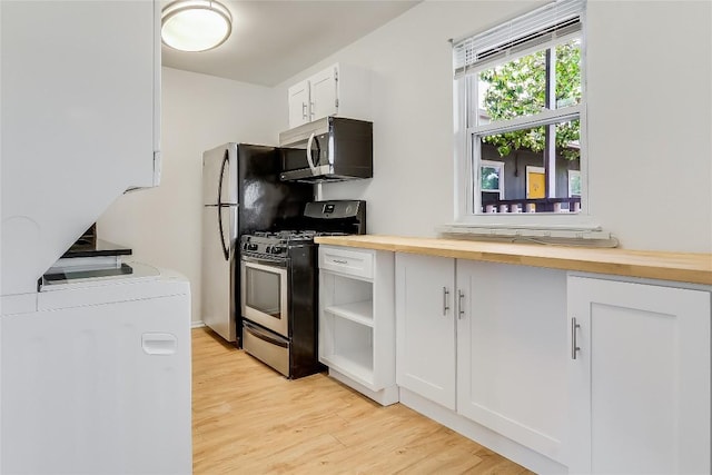 2401 Manor Rd Unit 210, Austin, TX 78722 - kitchen with appliances with stainless steel finishes, washer / dryer, light wood finished floors, butcher block counters, and white cabinetry