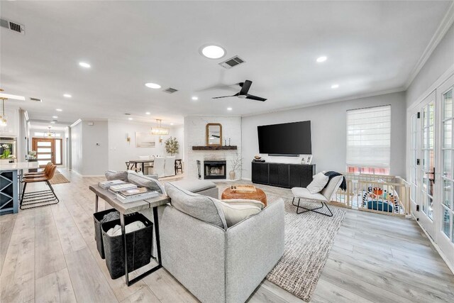 203 Sailors Run, Lakeway, TX 78734 - living room with ornamental molding, recessed lighting, ceiling fan, a large fireplace, and light wood-type flooring