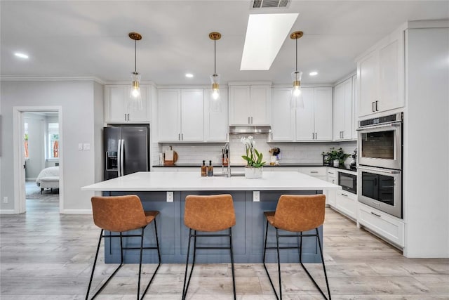 203 Sailors Run, Lakeway, TX 78734 - kitchen with refrigerator with ice dispenser, double oven, under cabinet range hood, white cabinets, and tasteful backsplash