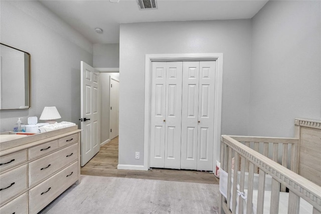 203 Sailors Run, Lakeway, TX 78734 - bedroom featuring light wood-style flooring, a closet, and a nursery area