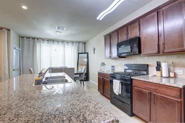 417 Epiphany Ln, Pflugerville, TX 78660 - kitchen with black appliances, decorative backsplash, light stone counters, and light tile patterned flooring