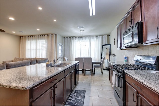 417 Epiphany Ln, Pflugerville, TX 78660 - kitchen with range with gas stovetop, black microwave, dishwasher, recessed lighting, and backsplash