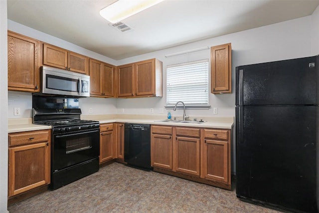 17737 Golden Valley Dr, Manor, TX 78653 - kitchen with black appliances, light countertops, and brown cabinets