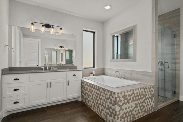 205 Honey Locust Cv, Leander, TX 78641 - full bath featuring vanity, a bath, wood finished floors, a stall shower, and recessed lighting