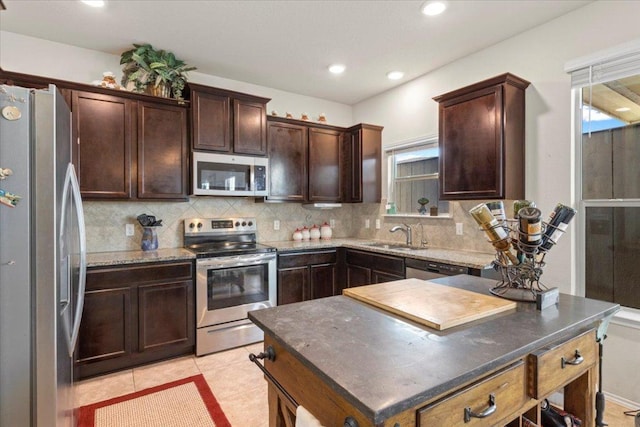 212 Plata Ln, Jarrell, TX 76537 - kitchen featuring stainless steel appliances, healthy amount of natural light, decorative backsplash, dark brown cabinetry, and recessed lighting