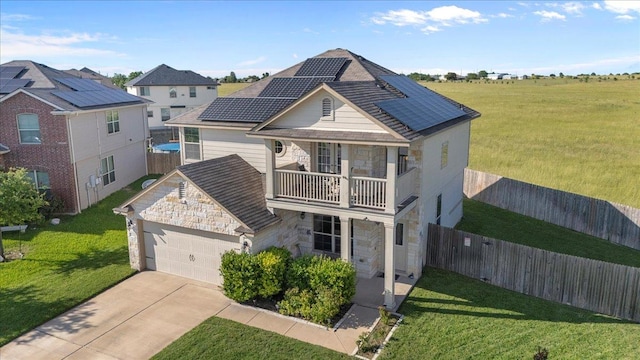 212 Plata Ln, Jarrell, TX 76537 - view of front of home featuring stone siding, a balcony, solar panels, driveway, and a garage