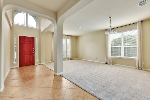 903 Fork Ridge Path, Round Rock, TX 78665 - entryway with light carpet, plenty of natural light, light tile patterned flooring, and a chandelier