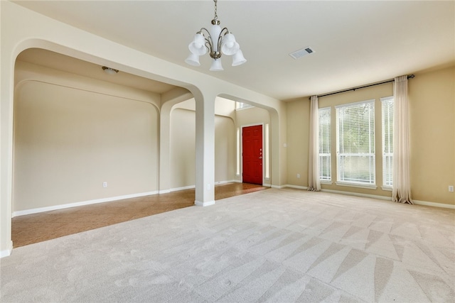 903 Fork Ridge Path, Round Rock, TX 78665 - unfurnished living room featuring arched walkways, carpet floors, and a chandelier