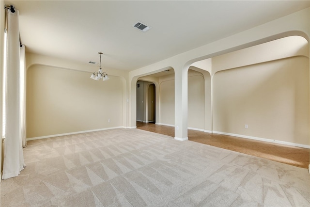 903 Fork Ridge Path, Round Rock, TX 78665 - empty room featuring light colored carpet, arched walkways, and a chandelier