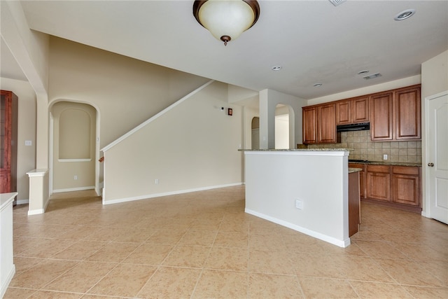903 Fork Ridge Path, Round Rock, TX 78665 - kitchen with light tile patterned floors, tasteful backsplash, brown cabinetry, and stone countertops