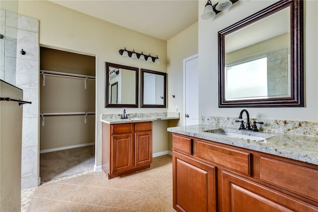 903 Fork Ridge Path, Round Rock, TX 78665 - bathroom with two vanities, tile patterned floors, and a walk in closet