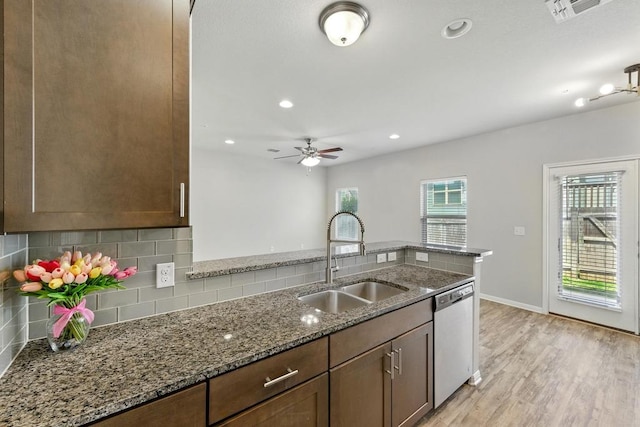 7202 Redding Dr Unit 203, Austin, TX 78745 - kitchen with stainless steel dishwasher, dark stone countertops, backsplash, light wood-style floors, and ceiling fan