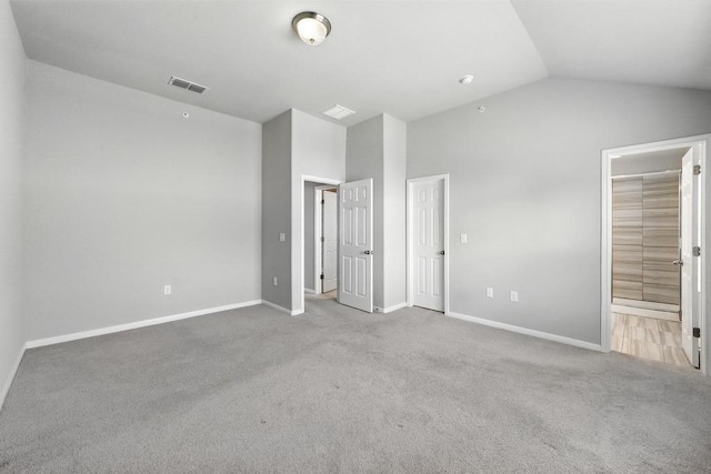 7202 Redding Dr Unit 203, Austin, TX 78745 - unfurnished bedroom featuring lofted ceiling, carpet, and connected bathroom
