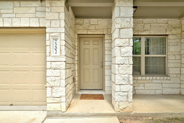 7202 Redding Dr Unit 203, Austin, TX 78745 - doorway to property with stone siding and a garage