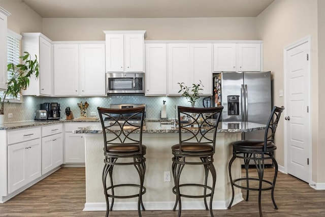 2302 Dillon Pond Ln Unit A, Pflugerville, TX 78660 - kitchen featuring stainless steel appliances, white cabinetry, wood finished floors, and a kitchen island