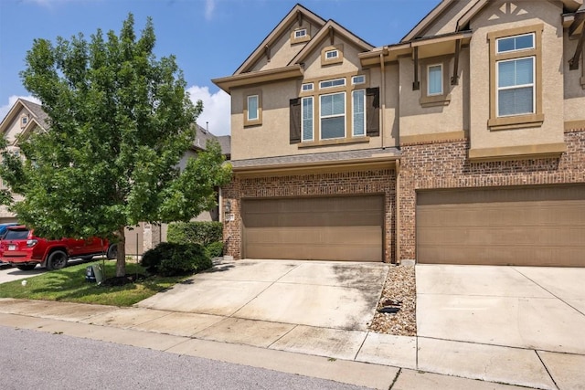 2302 Dillon Pond Ln Unit A, Pflugerville, TX 78660 - view of front of property with stucco siding, driveway, an attached garage, and brick siding