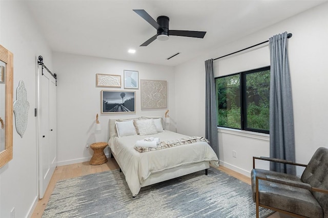 4808 Ranch Rd Unit 2222, Austin, TX 78731 - bedroom featuring a barn door, wood finished floors, a ceiling fan, and recessed lighting