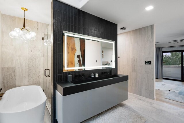 4808 Ranch Rd Unit 2222, Austin, TX 78731 - full bath featuring tile walls, a freestanding bath, vanity, a chandelier, and a shower stall