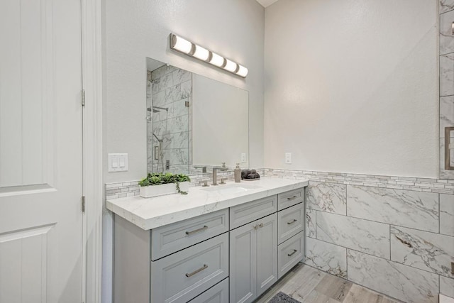 13201 Mansfield Dr, Austin, TX 78732 - bathroom with a shower stall, vanity, tile walls, and wood finished floors