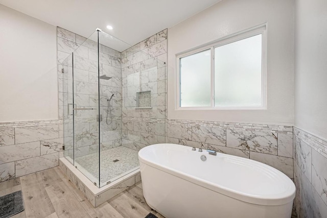 13201 Mansfield Dr, Austin, TX 78732 - full bath featuring tile walls, a stall shower, a soaking tub, a wainscoted wall, and wood finished floors
