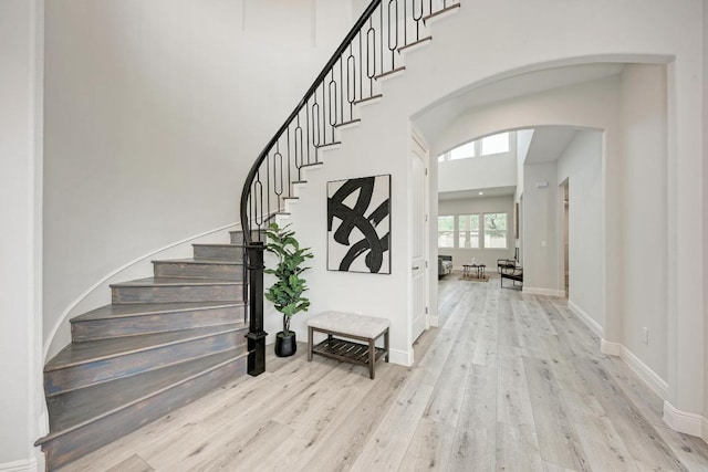 13201 Mansfield Dr, Austin, TX 78732 - stairs featuring wood finished floors, arched walkways, and a high ceiling