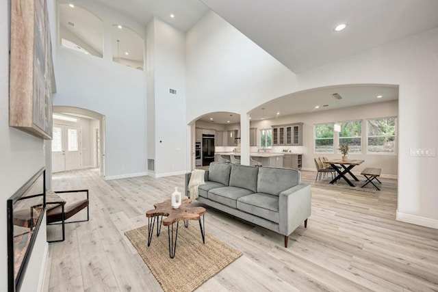 13201 Mansfield Dr, Austin, TX 78732 - living room with arched walkways, light wood-style flooring, and recessed lighting