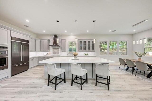 13201 Mansfield Dr, Austin, TX 78732 - kitchen with appliances with stainless steel finishes, wall chimney exhaust hood, light countertops, backsplash, and recessed lighting