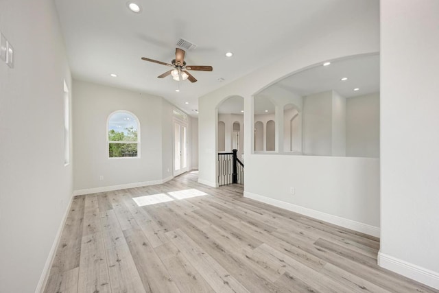 13201 Mansfield Dr, Austin, TX 78732 - unfurnished living room featuring recessed lighting, light wood-style floors, a ceiling fan, and arched walkways