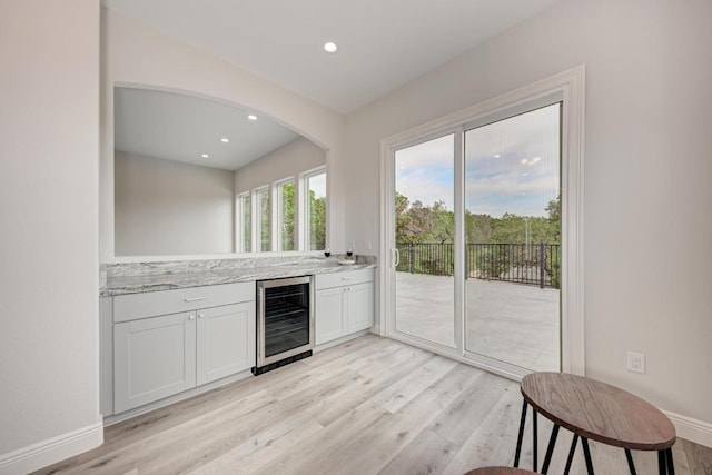 13201 Mansfield Dr, Austin, TX 78732 - indoor dry bar with wine cooler, light wood finished floors, recessed lighting, and arched walkways