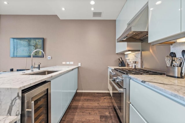 200 Congress Ave Unit 33Bb, Austin, TX 78701 - kitchen featuring beverage cooler, high end stainless steel range, under cabinet range hood, white cabinets, and recessed lighting