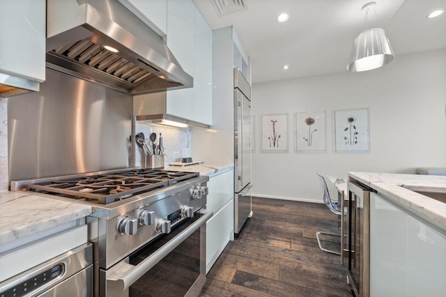 200 Congress Ave Unit 33Bb, Austin, TX 78701 - kitchen with high quality appliances, wall chimney range hood, modern cabinets, white cabinets, and dark wood-style floors