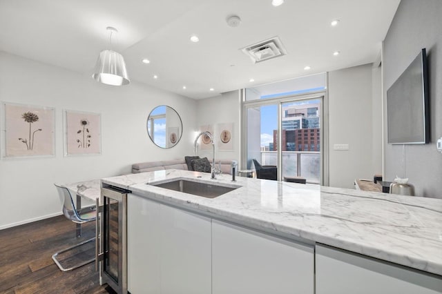 200 Congress Ave Unit 33Bb, Austin, TX 78701 - kitchen featuring wine cooler, dark wood-style floors, white cabinets, light stone counters, and recessed lighting