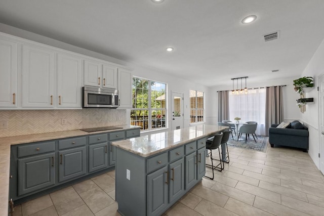 2308 Windswept Dr, Austin, TX 78738 - kitchen with stainless steel microwave, gray cabinets, white cabinets, black electric cooktop, and recessed lighting