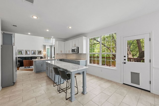 2308 Windswept Dr, Austin, TX 78738 - kitchen with stainless steel appliances, gray cabinets, recessed lighting, a center island, and backsplash