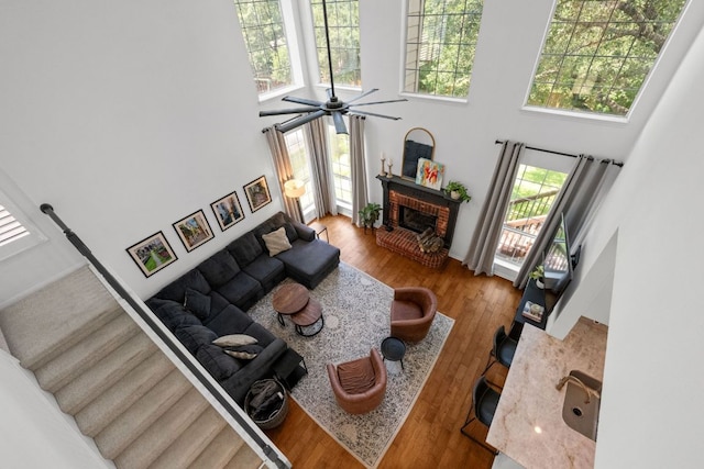 2308 Windswept Dr, Austin, TX 78738 - living room featuring a high ceiling, a brick fireplace, plenty of natural light, wood finished floors, and a ceiling fan