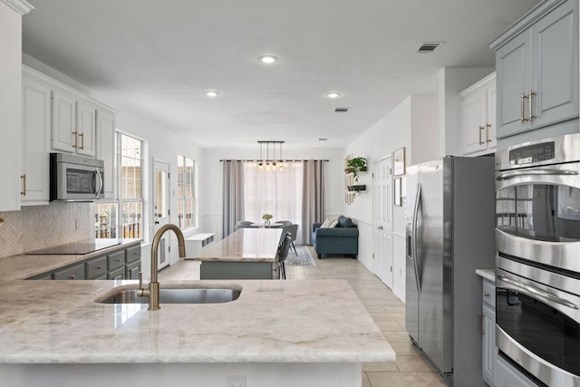 2308 Windswept Dr, Austin, TX 78738 - kitchen featuring appliances with stainless steel finishes, recessed lighting, backsplash, light stone countertops, and light tile patterned flooring