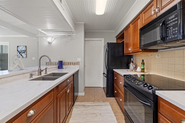 100 Lido Cir Unit B-1, Lakeway, TX 78734 - kitchen with black appliances, backsplash, brown cabinetry, crown molding, and light tile patterned flooring