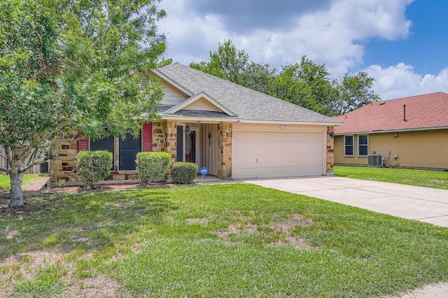 1229 Twin Cv, Kyle, TX 78640 - single story home featuring a garage, driveway, a front yard, stone siding, and a shingled roof