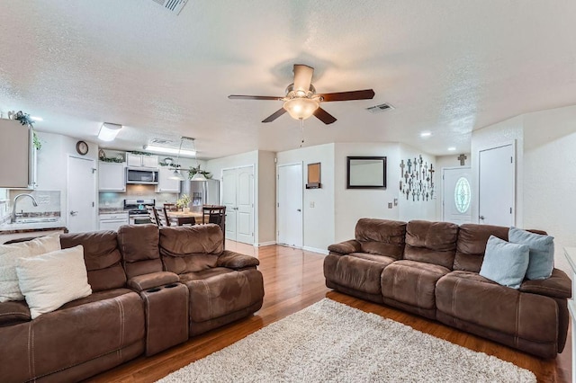 1229 Twin Cv, Kyle, TX 78640 - living area with light wood-style flooring, a textured ceiling, and ceiling fan