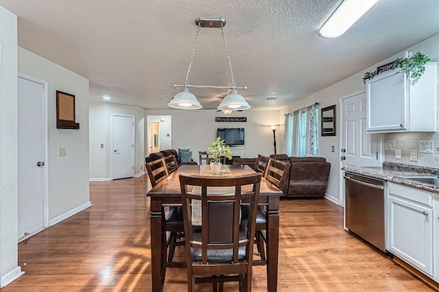 1229 Twin Cv, Kyle, TX 78640 - dining area featuring light wood-type flooring and a textured ceiling